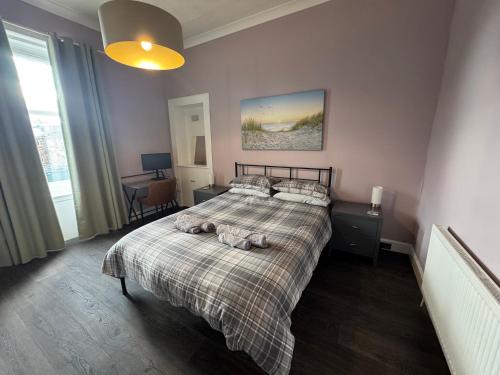 a bedroom with a bed with two towels on it at Dunes Apartment Troon in Troon