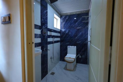 a bathroom with a toilet and a sink at Mount Zion Holidays in Kuttālam