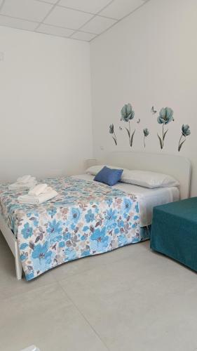 a bedroom with a bed with blue flowers on the wall at Dimora L&A in Portocannone
