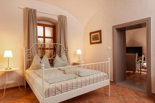 a white bed in a room with a mirror at Köveskál Vendégház in Köveskál