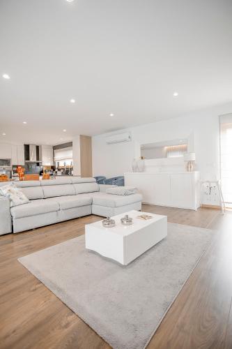 a living room with white furniture and a white table at Casa Fregim in Amarante