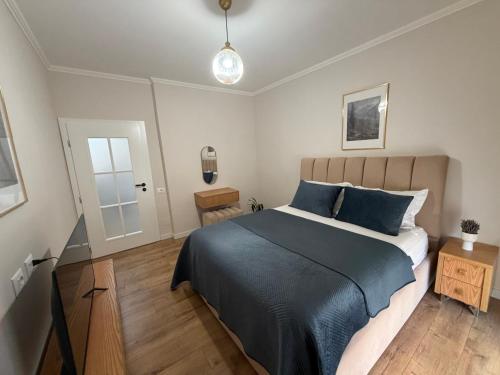 a bedroom with a large bed with a blue blanket at Koko Pepito apartment in Lezhë