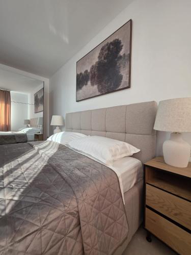 a bedroom with a bed and a picture on the wall at Colins Premium Apartments in Giurgiu