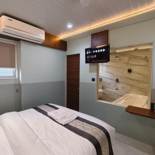 a bedroom with a bed and a tub and a tv at Mi Residency Lodging & Boarding in Thane