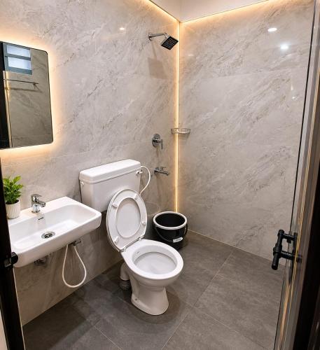 a bathroom with a toilet and a sink at Levora Suits in Kottayam