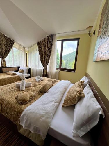 a bedroom with two beds and a window at Pensiunea Un colț de Rai in Lunca Jariştei