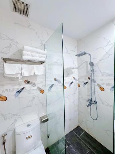 a bathroom with a shower and a toilet at Bay Homestay in Cam Lâm