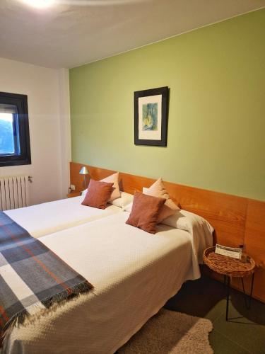 two beds in a room with green walls at HOTEL PIORNEDO in Lugo