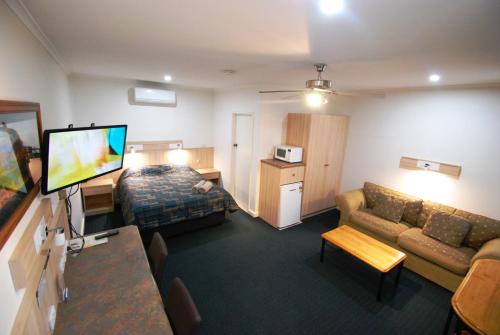 a hotel room with a bed and a couch at Comfort Inn & Suites Augusta Westside in Port Augusta