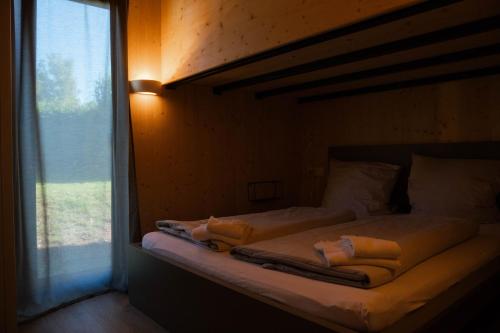 a bed with towels sitting on it next to a window at Wellnester Tiny Houses in Losheim am See in Losheim