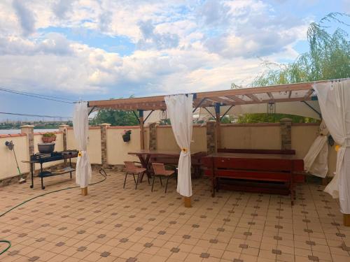 a pavilion with a table and benches on a patio at Nistor House-Delta Retreat in Tulcea