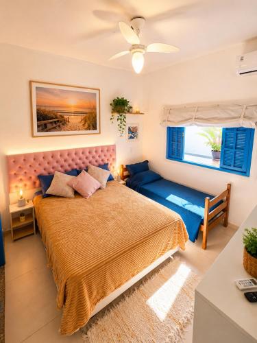 a bedroom with a large bed and a blue couch at Piratas Guest Rooms II in Búzios