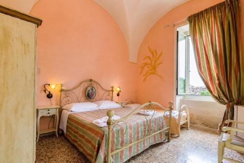a bedroom with a bed and a window at Tenuta Masseria del Gallo in Calimera