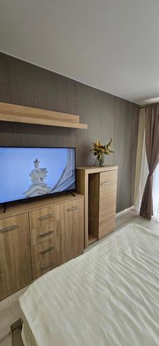 a bedroom with a flat screen tv and a bed at Yellow Apartment Mažeikiai in Mažeikiai