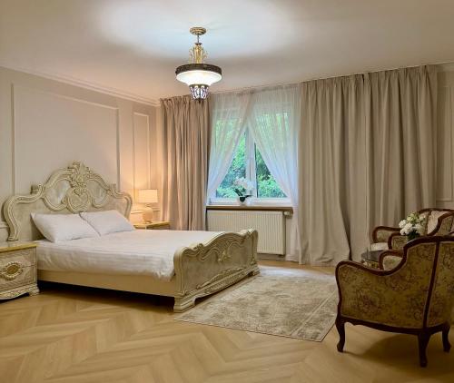 a bedroom with a bed and a chair and a window at Hotel Pałac Akropol in Lublin