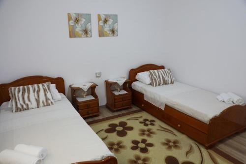 a room with two beds and two night stands at Swimming Pool - Leko House Perondi in Kuçovë