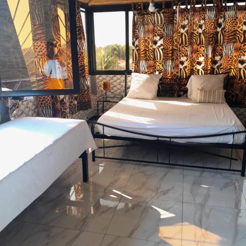 a bedroom with two beds and a window at Guest House MM in Saly Portudal