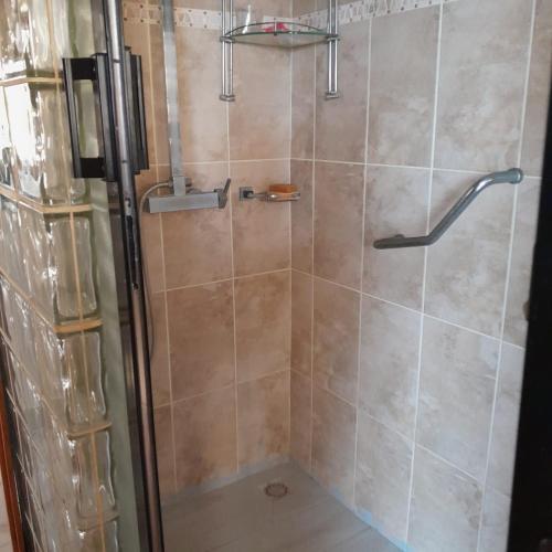 a shower with a glass door in a bathroom at Guest House MM in Saly Portudal