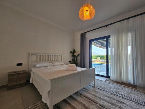 a bedroom with a large bed and a large window at Private Pool Villa with Jacuzzi & Garden in Girdev