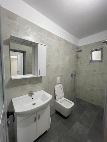 a white bathroom with a sink and a toilet at Aparthotel Borsh in Borsh