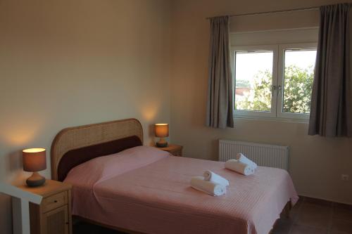 a bedroom with a bed with two towels on it at Oleander Villa in Rafina