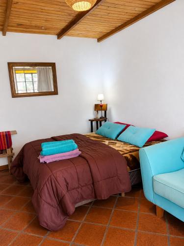 a bedroom with a bed and a blue couch at Posada Tordillo Hosteria Rural in Chascomús