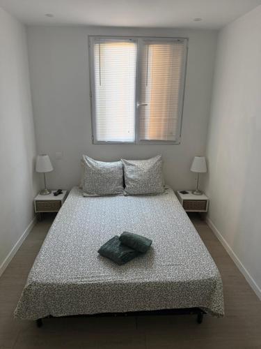 a bedroom with a large bed with two windows at Location dans résidence privée,sécurisée ,parking gratuit , 1 minute du tramway, à 9 minute du centre ville, accessible à plusieurs transports in Nice