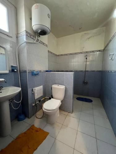 a bathroom with a toilet and a sink at Residence el baraka in Bou Zadjar
