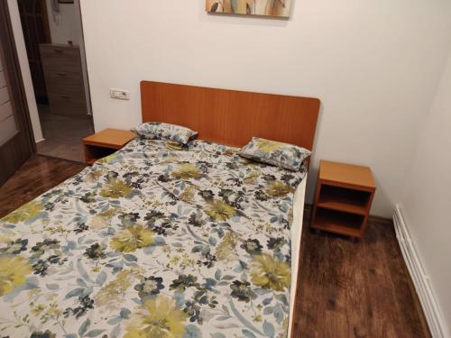 a bedroom with a bed with a floral bedspread at Apartament Centru in Râmnicu Vâlcea