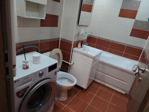 a bathroom with a washing machine and a toilet at Apartament Centru in Râmnicu Vâlcea