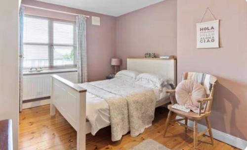 a bedroom with a bed and a chair and a window at Southeast Getaway in Limerick