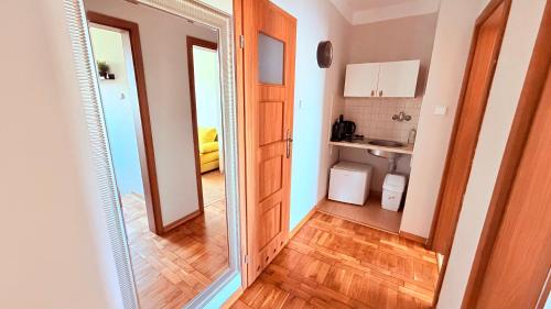 a hallway with a mirror and a kitchen at MERKADO in Darlowko