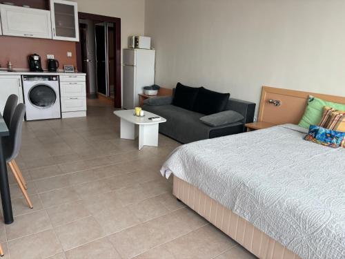 a bedroom with a bed and a couch and a kitchen at Miramar Palace 612S in Sunny Beach
