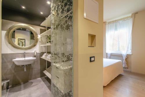 a bathroom with a sink and a bed and a mirror at Hotel Liberty in Levico Terme