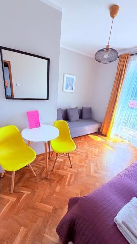 a living room with a table and two yellow chairs at MERKADO in Darlowko