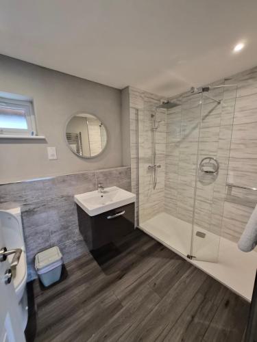 a bathroom with a shower and a sink and a mirror at The Garden Rooms at Tannery House in Bakewell