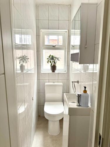 a small bathroom with a toilet and a sink at Stylish 2BR Flat 3 Mins to Wembley Stadium in London