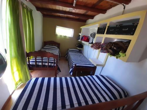 a bedroom with two beds and chairs in a room at Los 2 Hermanos in Tanti