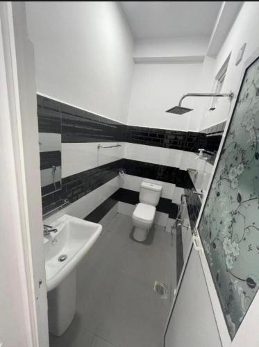 a bathroom with a toilet and a sink at NRT Beach Hotel in Trincomalee