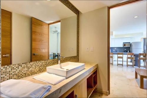 a bathroom with a sink and a mirror at Anah Suites by Las Flores Vacation Rentals in Playa del Carmen
