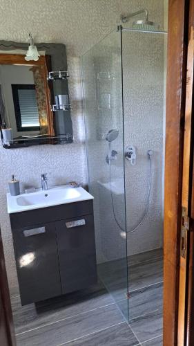 a bathroom with a glass shower and a sink at Dar Zakia in Soliman