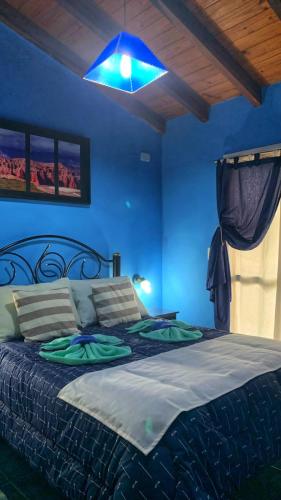 a blue bedroom with a bed with a blue light at Complejo sierras de brochero in Villa Cura Brochero