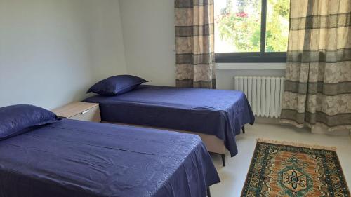 a bedroom with two beds and a window at Dar Zakia in Soliman