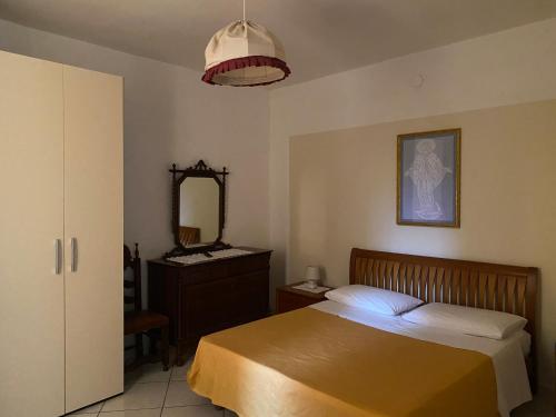 a bedroom with a bed and a dresser and a mirror at ZIO DOMENICO Al Vicolo in Castellabate