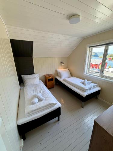 a room with two beds and a window at ROOMS by Kåkern Bridge in Sund