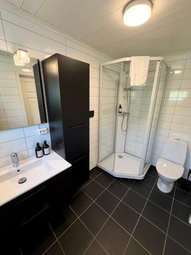 a bathroom with a shower and a sink and a toilet at ROOMS by Kåkern Bridge in Sund