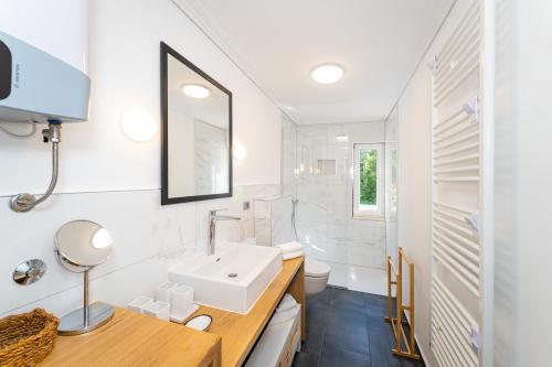 a white bathroom with a sink and a mirror at Apartment Ana with private pool in Otok