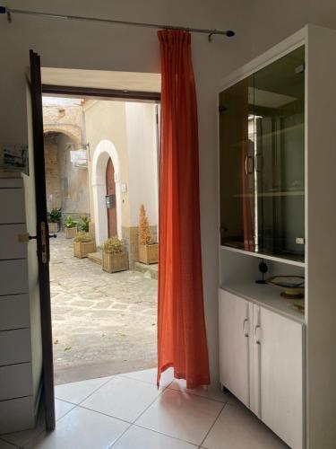 an open door to a kitchen with an orange curtain at ZIO DOMENICO Al Vicolo in Castellabate