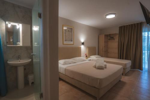 a hotel room with two beds and a sink at ATHINA MARE-SOLE in Kallithea Halkidikis