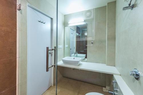 Un baño con lavabo, inodoro y ducha. en Blue Bells, en Valsad